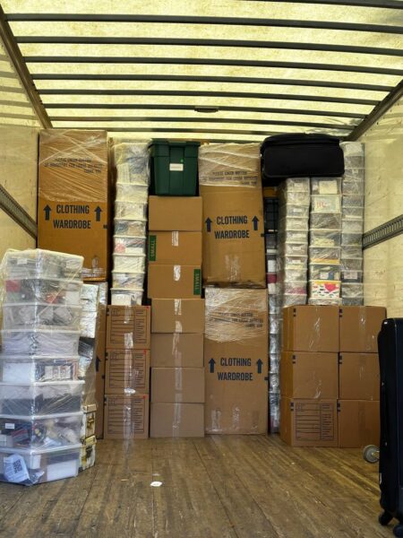 neatly packed moving truck loaded with labeled boxes, bins, and wardrobe cartons